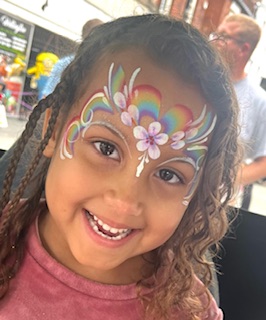 Girl with rainbow face painting in Telford